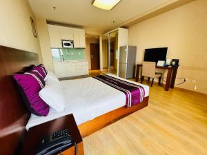 a hotel room with a bed and a kitchen at Pumpkin Hotel in Beijing