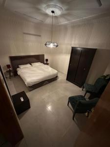 a bedroom with a bed and chairs in it at Güzellik Junior Suite جناح قوزيوليك in Abha