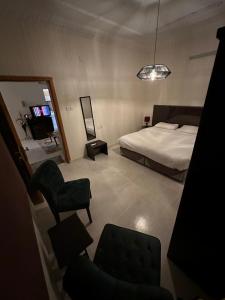 a bedroom with a bed and a chair and a mirror at Güzellik Junior Suite جناح قوزيوليك in Abha