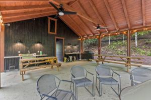 a patio with chairs and a table and a wooden ceiling at Creekside - Camping Cabin Retreat - RRG KY in Rogers