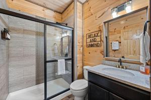 a bathroom with a shower and a toilet and a sink at Pet-Friendly Sevierville Cabin, Hot Tub, Air Hock in Sevierville +30 photos