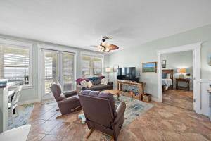 a living room with a couch and a tv at Pointe West 302 - Sunset on the Bay in Galveston
