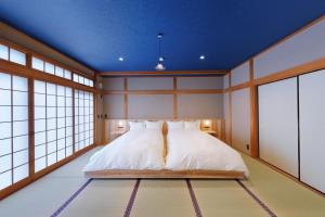 ein Schlafzimmer mit einem Bett in einem Zimmer mit Fenstern in der Unterkunft Hirado - House - Vacation STAY 20271 in Tasuke