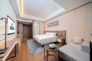 a hotel room with a bed and a couch at Days Hotel Guangzhou Haizhu in Guangzhou