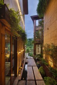 een loopbrug tussen twee gebouwen met een vijver bij Meilanmeilv Forest Luxe Inn-Chengdu Sansheng Township Branch in Ta-mien-chen