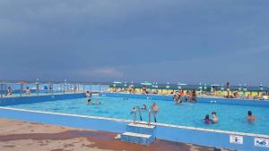 洛萨皮内塔Mobilehomes in Rosolina Mare 33791的一群人在海滩上的游泳池里 更多7张照片