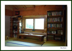 a room with a window and a bench in front of a book shelf at 숲속 작은 황토집 