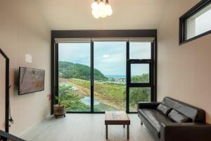 Una sala de estar con un sofá y una ventana grande. en Trip Recipe, en Sinŏm-ni 34 fotos más