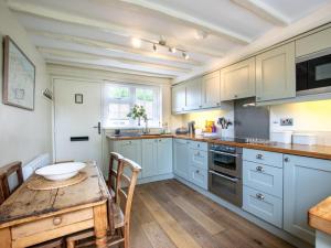 Una cocina con gabinetes azules y una mesa de madera. en 2 Bed in Kelling 76755, en Kelling