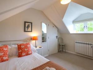 Un dormitorio con una cama con almohadas naranjas y blancas. en 2 Bed in Kelling 76755, en Kelling