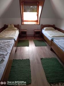 two beds in a room with green rugs on the floor at Holiday home Vonyarcvashegy - Balaton 31295 in Vonyarcvashegy +22 photos