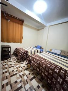 a hotel room with two beds and a ceiling at Curahuasi Backpackers in Curahuasi +12 photos