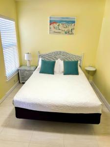 a bedroom with a large bed with blue pillows at Welcoming 2-bedroom condo with bonus room! in Indian Shores
