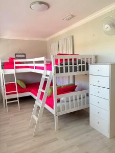 a bedroom with two bunk beds with red pillows at Welcoming 2-bedroom condo with bonus room! in Indian Shores