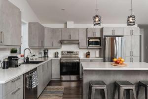 eine Küche mit Geräten aus Edelstahl und grauen Schränken in der Unterkunft Chalet Ankoay - Relaxation Nature & Private Spa in Saint Come