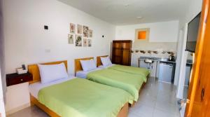 two beds in a room with a kitchen at Shark house dahab in Dahab