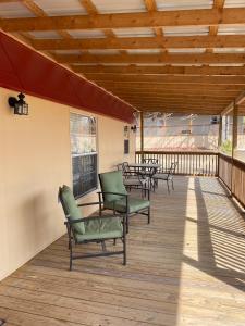 a deck with chairs and tables and a wooden ceiling at Comfortable Cabin Rental on a Winery for a Romantic Getaway in Oklahoma in Allen