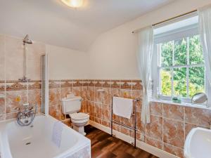 ein Badezimmer mit Badewanne und Toilette und einem Fenster in der Unterkunft 3 Bed in Ullswater SZ398 in Watermillock + 18 Fotos