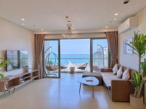 a living room with a couch and a large window at Ocean Pearl The Sóng Apartment - Vung Tau City - Căn Hộ View Biển, Hồ Bơi Vô Cực in Vung Tau