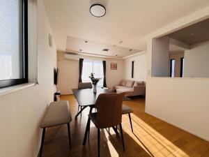 a dining room and living room with a table and chairs at 福の荘唐人町a棟 in Fukuoka