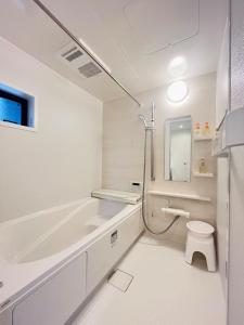 a white bathroom with a tub and a toilet at 福の荘唐人町a棟 in Fukuoka +66 photos