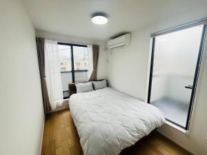 a small bedroom with a bed and a window at 福の荘唐人町a棟 in Fukuoka