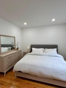 a bedroom with a bed with a mirror and a dresser at Cozy Retreat Near EWR with NYC access in Newark