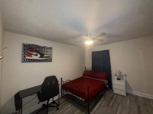 a bedroom with a red bed and a ceiling fan at Serene Sunshine State Escape in Deltona