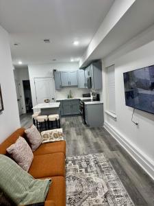 a living room with a couch and a kitchen at Cozy Retreat Near EWR with NYC access in Newark