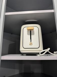 a toaster is sitting on a shelf at Cozy Retreat Near EWR with NYC access in Newark +19 photos