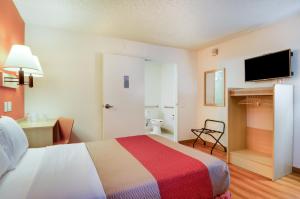a hotel room with a bed with a colorful blanket at Motel 6-Tacoma, WA - Fife in Fife