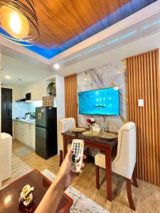 een persoon die een afstandsbediening vasthoudt in een keuken met een tafel bij J&J Havenstay Ananda Square in Manilla +92 foto's