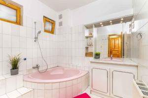 a bathroom with a pink tub and a sink at Holiday home Balatonbereny - Balaton 18099 in Part +7 photos