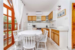a white kitchen with a table and chairs in it at Holiday home Balatonbereny - Balaton 18099 in Part