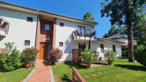 een groot wit huis met een hek en een tuin bij Apartments in Szantod - Balaton 35823 in Szántód +20 foto's