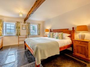 a bedroom with a large bed and two windows at 5 Bed in Threlkeld SZ270 in Threlkeld