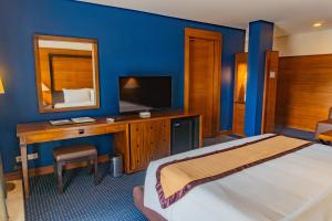a bedroom with a bed and a desk with a mirror at Boracay Sands Hotel in Boracay +24 photos