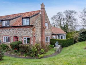 an old stone house with a grassy yard at 2 Bed in Kelling NCC25 in Kelling