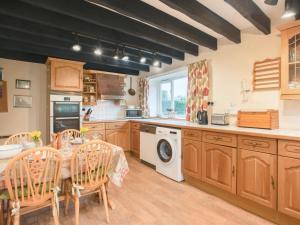 a kitchen with wooden cabinets and a table and chairs at 2 Bed in Kelling NCC25 in Kelling