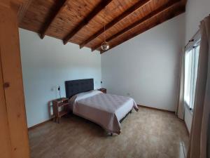 een slaapkamer met een bed, een tafel en een raam bij Bosquemolinos in Villa Los Molinos