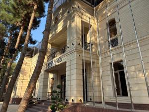 サマルカンドにあるAD Bellagioの前にヤシの木がある建物