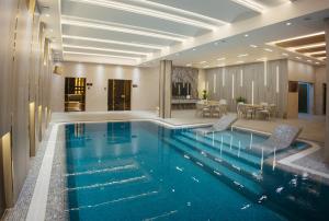 サマルカンドにあるAD Bellagioの椅子とテーブルが備わったホテルのプール