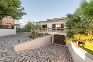 a white house with a balcony and a courtyard at Cas Fraus in Sa Coma
