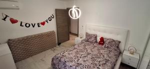 a bedroom with a bed and a love sign on the wall at Modern & Comfortable Apartment in Aouina in El Aouina Station +5 photos