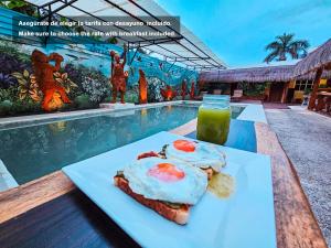 a plate of food on a table next to a pool at Mayas Blue Bacalar in Bacalar