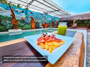 a plate of fruit on a table next to a pool at Mayas Blue Bacalar in Bacalar