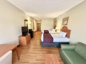 a hotel room with two beds and a couch at Americas Best Value Inn Wiggins in Wiggins +28 photos