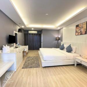 a bedroom with a large white bed and a desk at Curve Boutique Hotel in Pattaya Central +16 photos