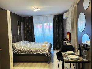 a bedroom with a bed and a table and a dining room at Apartman Elite Stay Doboj in Doboj