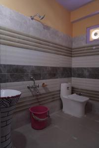 a bathroom with a toilet and a bath tub at Madhurvi baker's and homestay in Chitkul